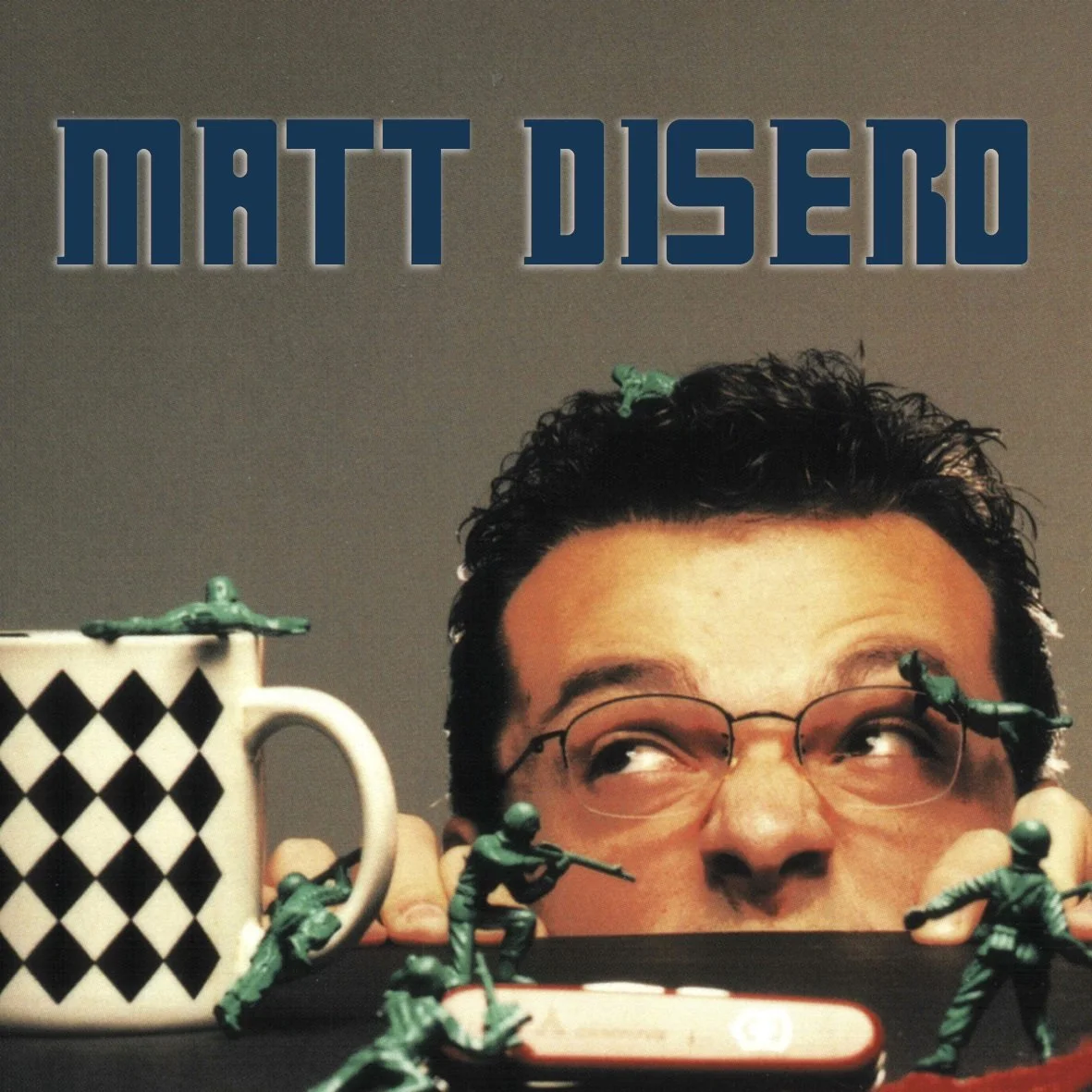 Matt DiSero Headshot peering over the table with plastic army men