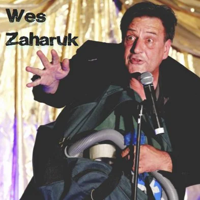 Wes Zaharuk performs a comedy magic trick with a vacuum cleaner in a duffel bag
