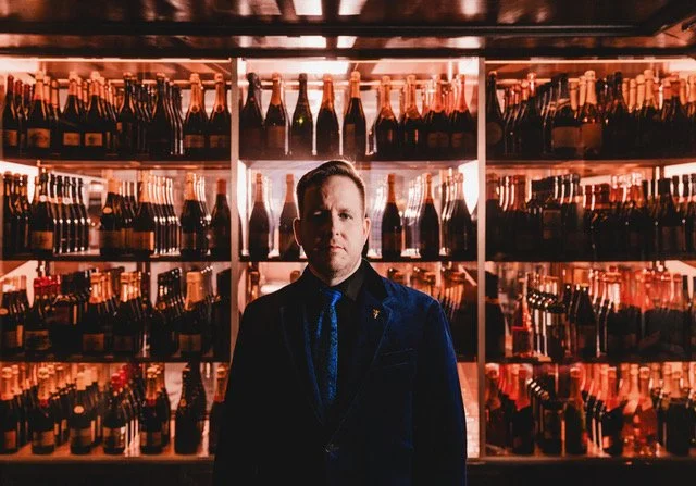 James Alan with champagne bottles large.jpeg