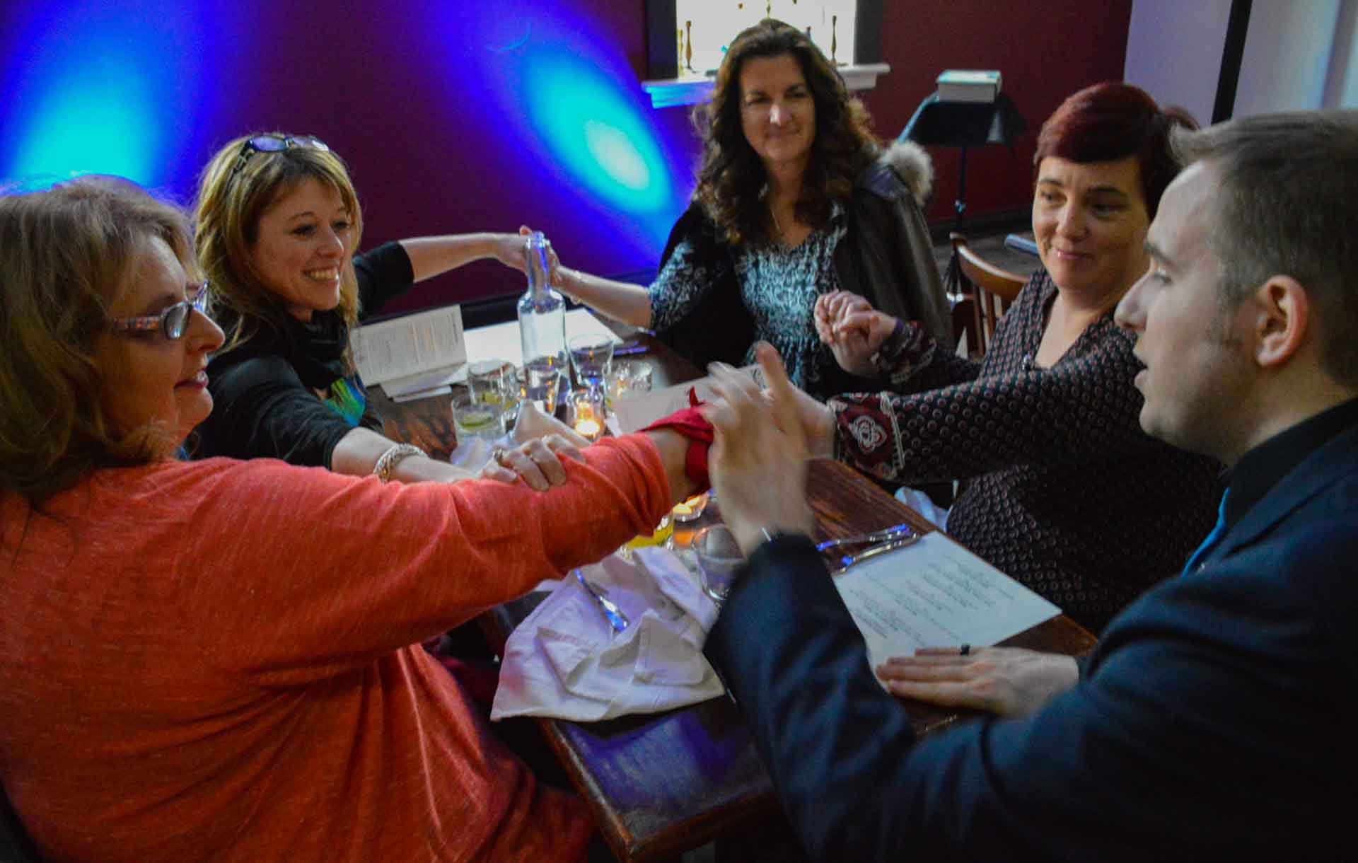 James Alan does a handkerchief trick around table at Grand Spirits Distillery