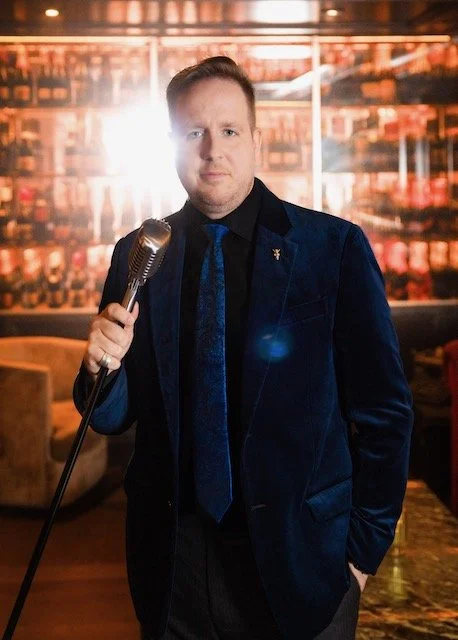 James Alan with champagne bottles and old fashioned microphone at À Toi
