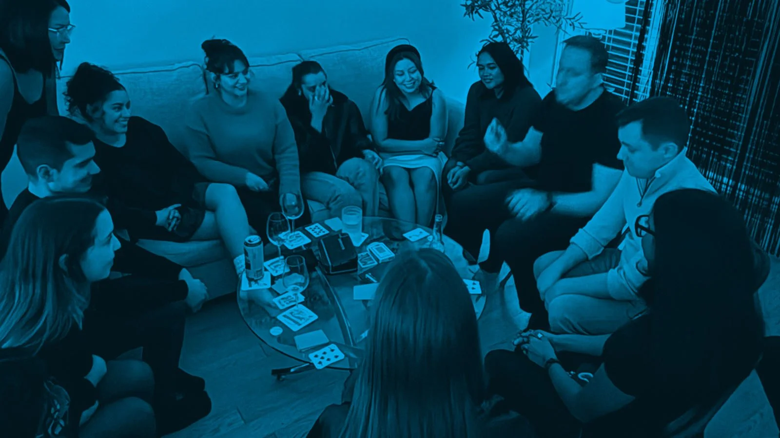 James Alan performing close-up magic for a small group around a coffee table