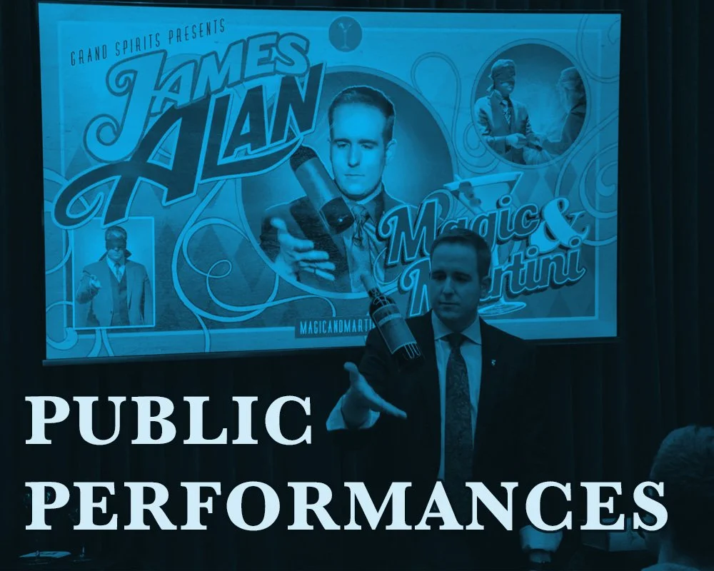 Link to public performances page James Alan standing in front of Magic and Martini Poster at Storm Crow Manor