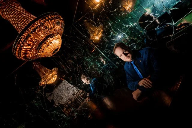 James Alan promo image at À Toi with chandelier reflected in shattered mirror