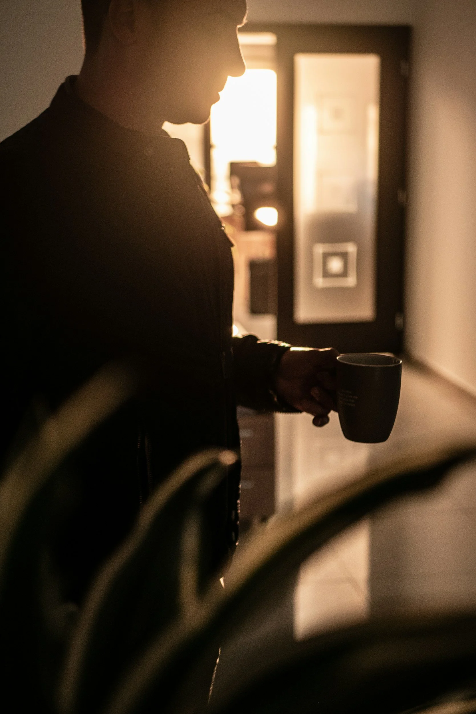 Man with coffee at office in sunlight