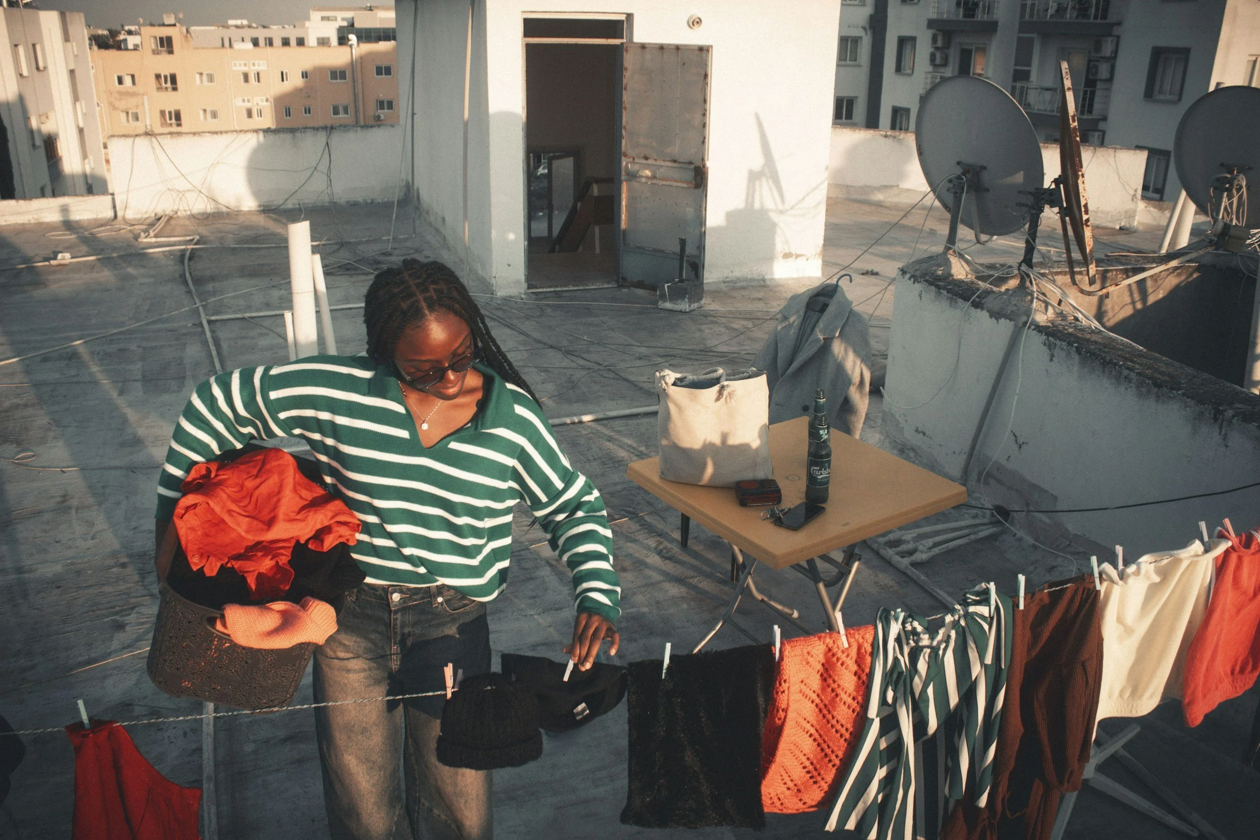woman hanging wet clothes on a line to dry in the sunshine