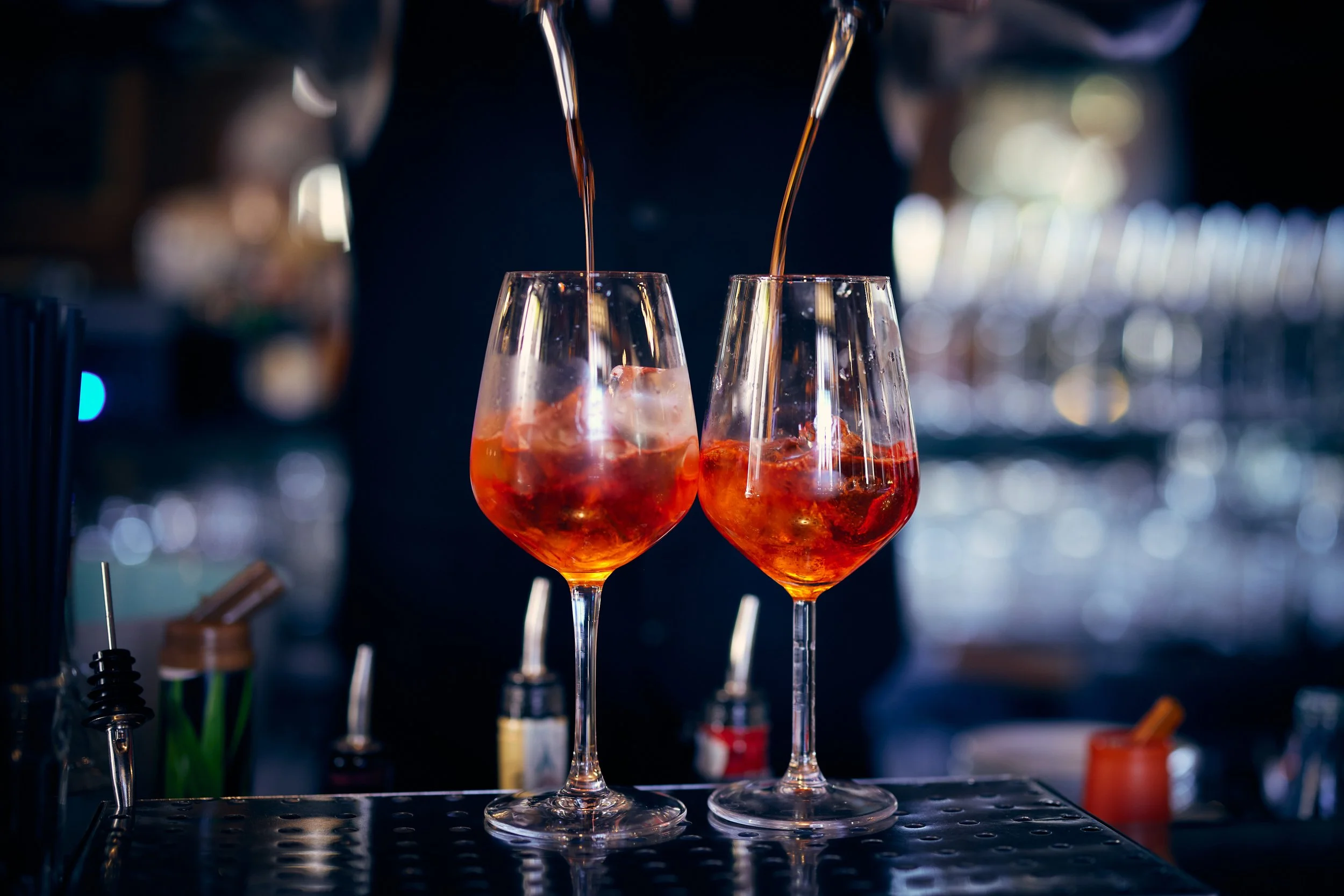 Close up of bar tender's hands pouring cocktails