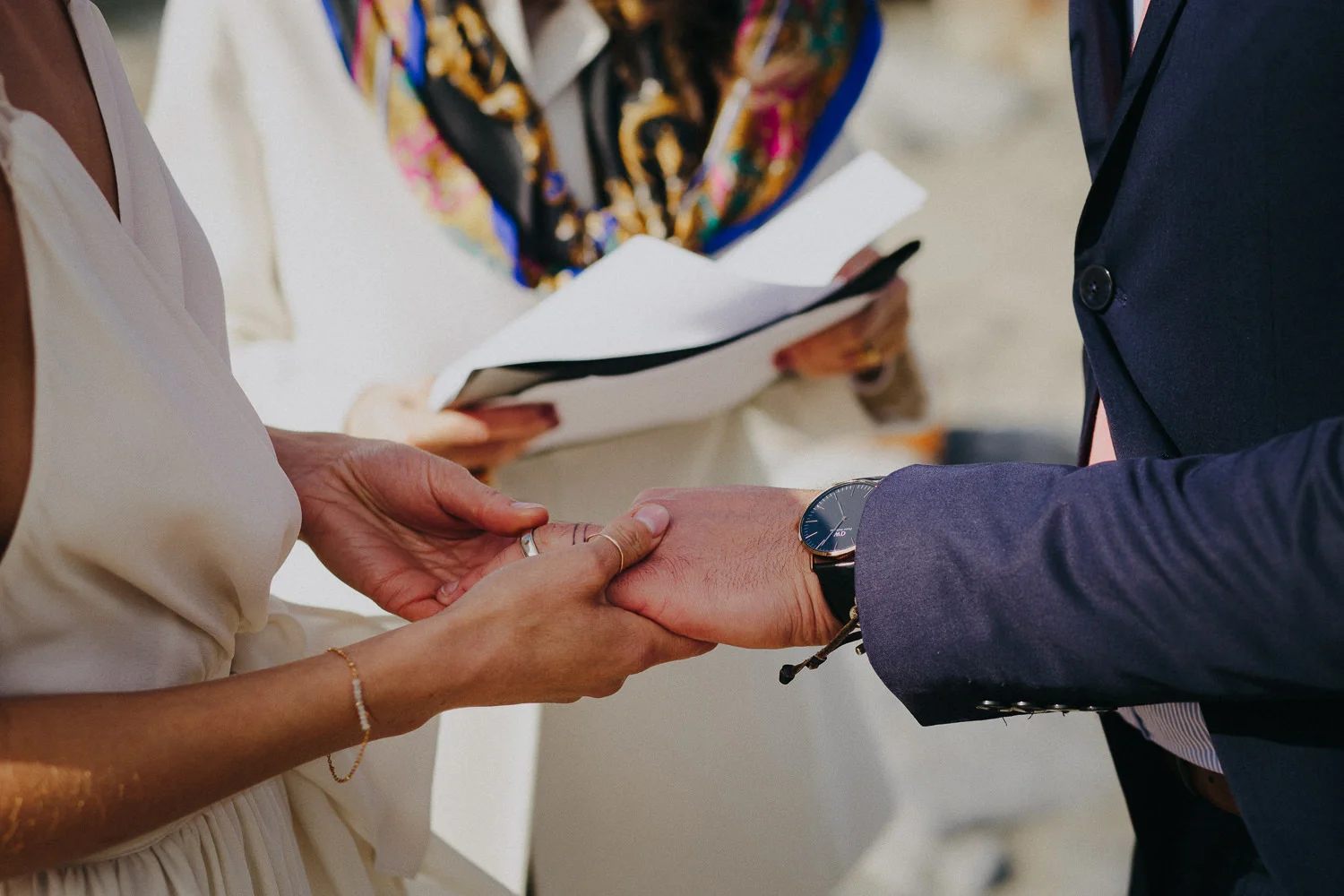 the bride putting the wedding ring on the groom