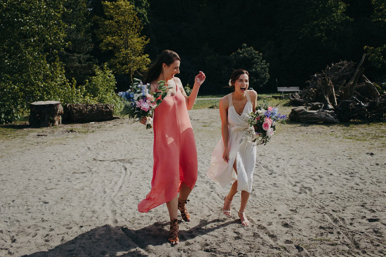 bride and maid of honor laughing on the beach
