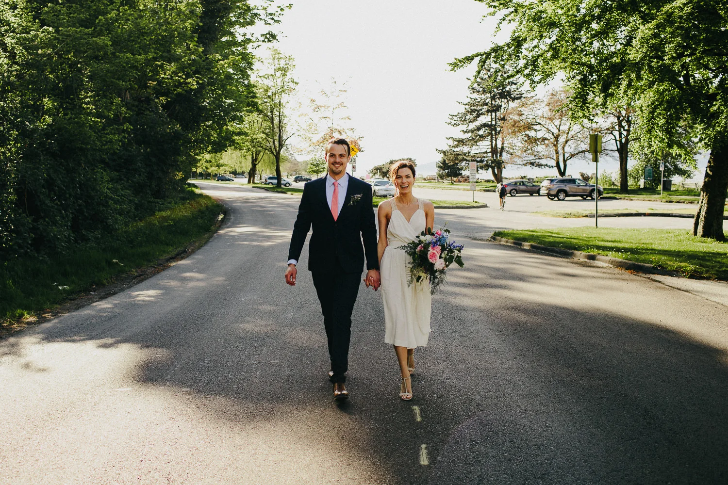bride and groom walking on a road in kitsilano