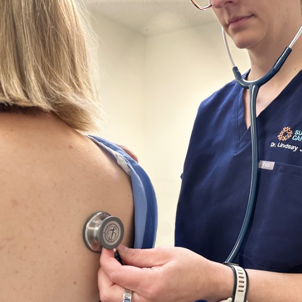 A naturopathic doctor listening to a patient's vital signs with a stethoscope.