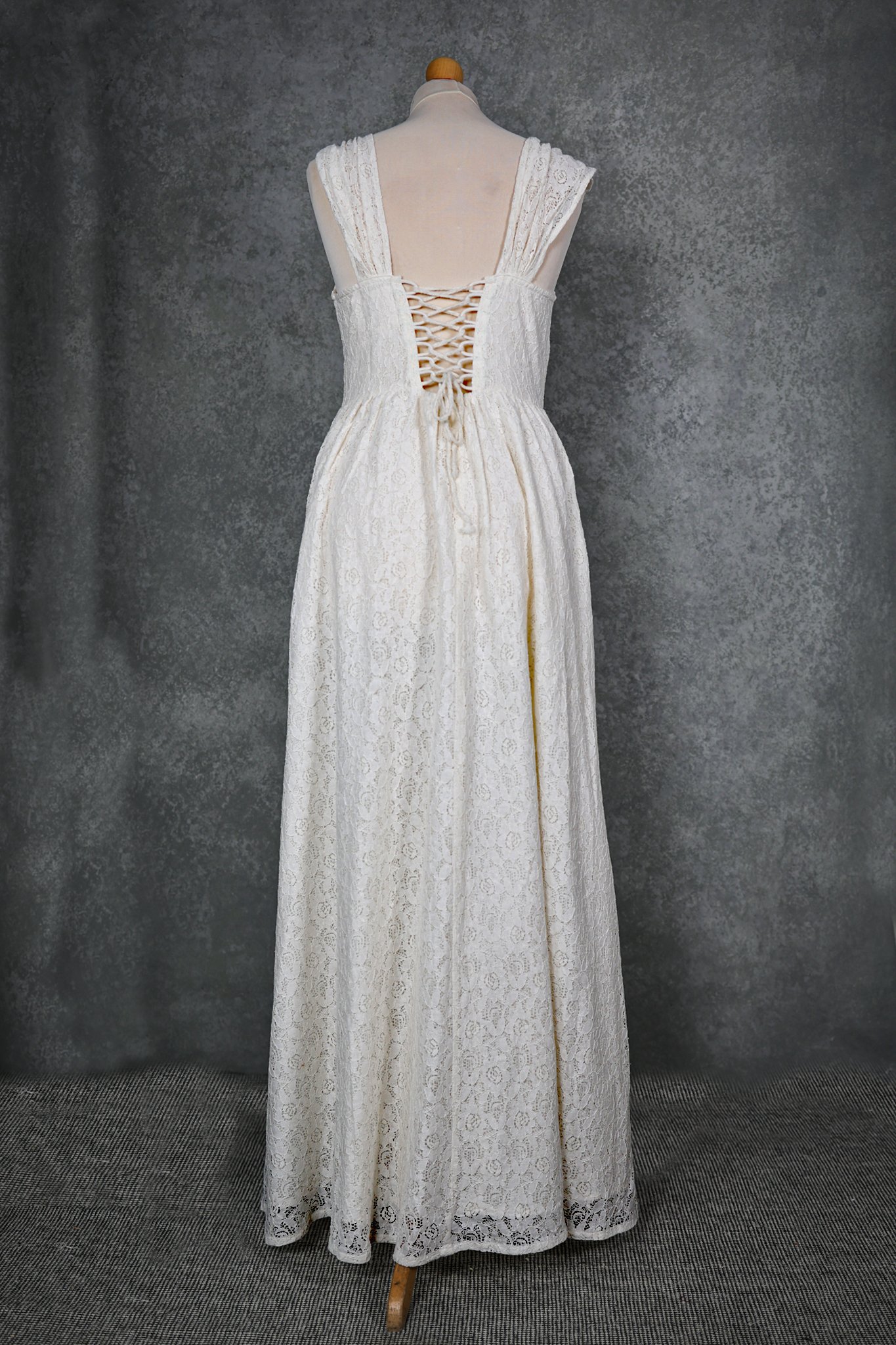 The Wild Rose Lace Gown is a romantic Irish lace wedding dress with corset back, gathered straps, and side slit—designed for brides seeking elegance and folklore charm.