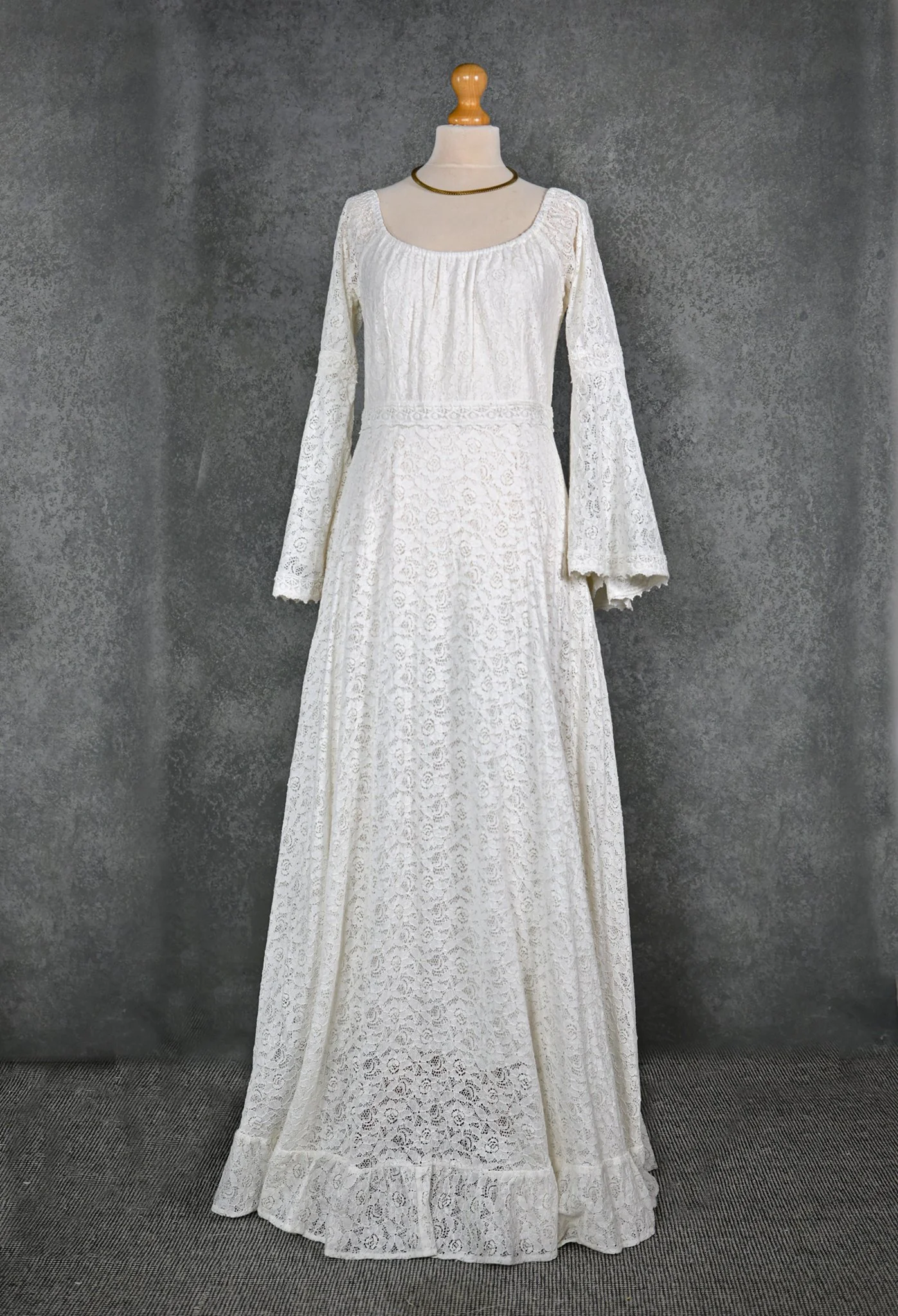 Bébhinn Boho Wedding Dress with off-the-shoulder neckline, bell sleeves, and flowing A-line cotton lace skirt. Custom-made for free-spirited brides.