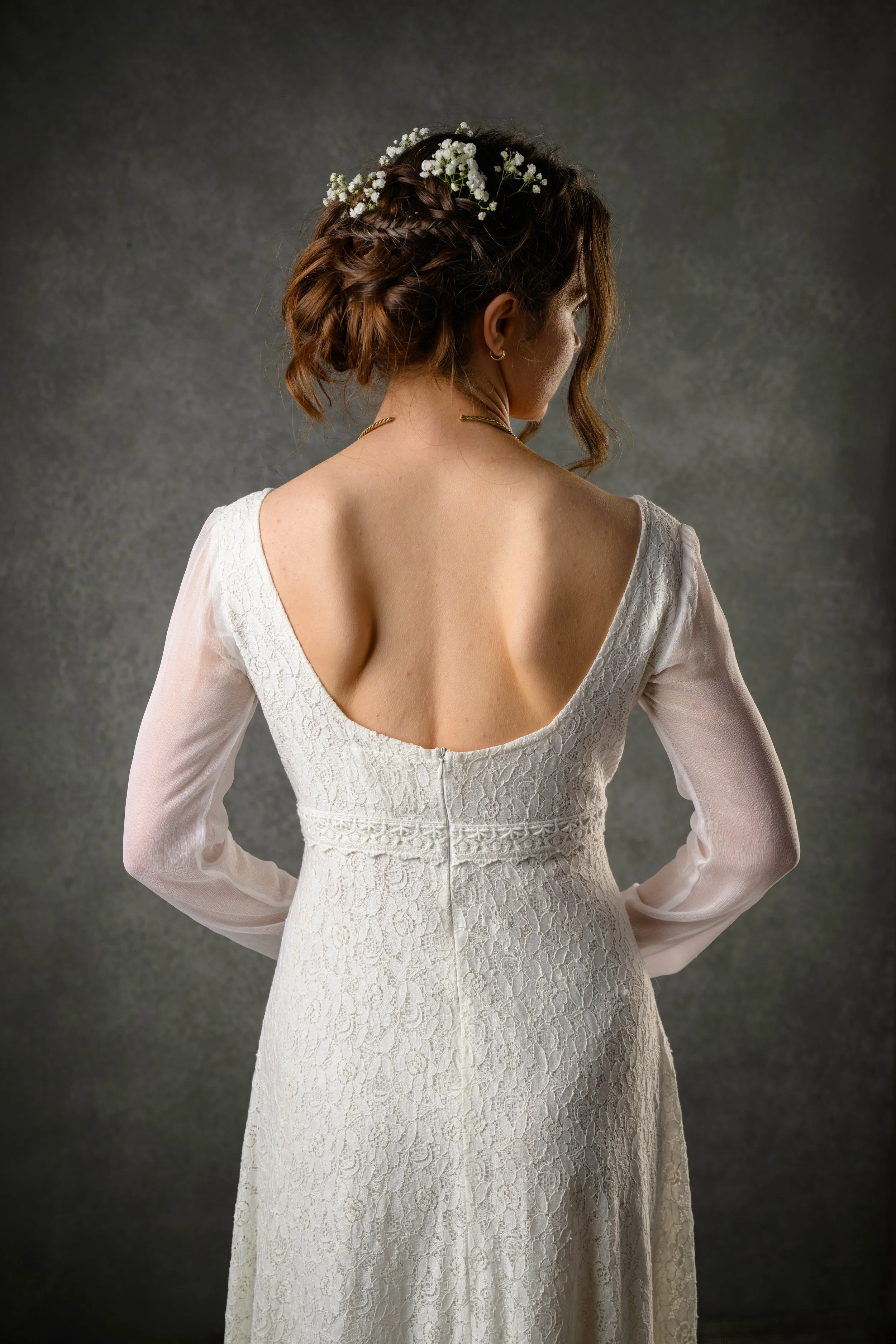 Regency style cotton lace wedding dress with bishop chiffon sleeves and a low scoop back. Features delicate waist lace trim and a ruffled hem.