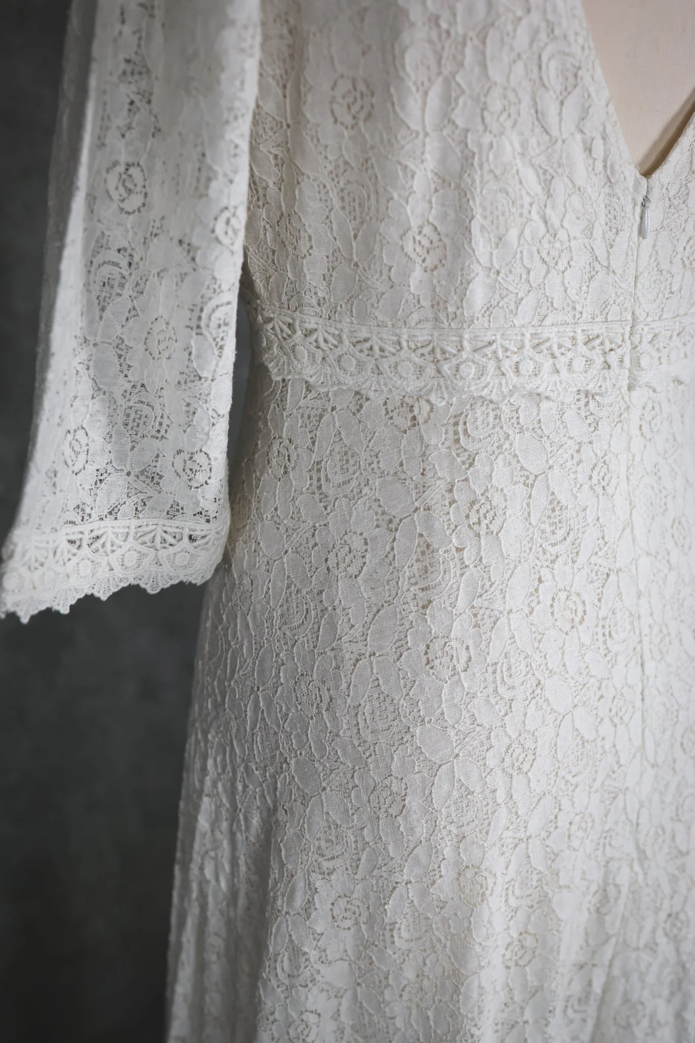 Willow Wedding Dress , a romantic Irish-designed gown made in soft ivory cotton lace, featuring a high neckline, V back, fluted sleeves, and a gathered frill hem