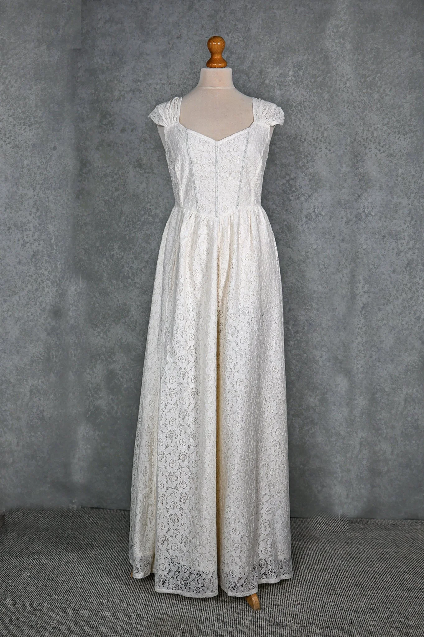 White Irish lace wedding dress with corset-style back, gathered lace straps, and flowing skirt with side slit—romantic Irish Celtic bridal design.