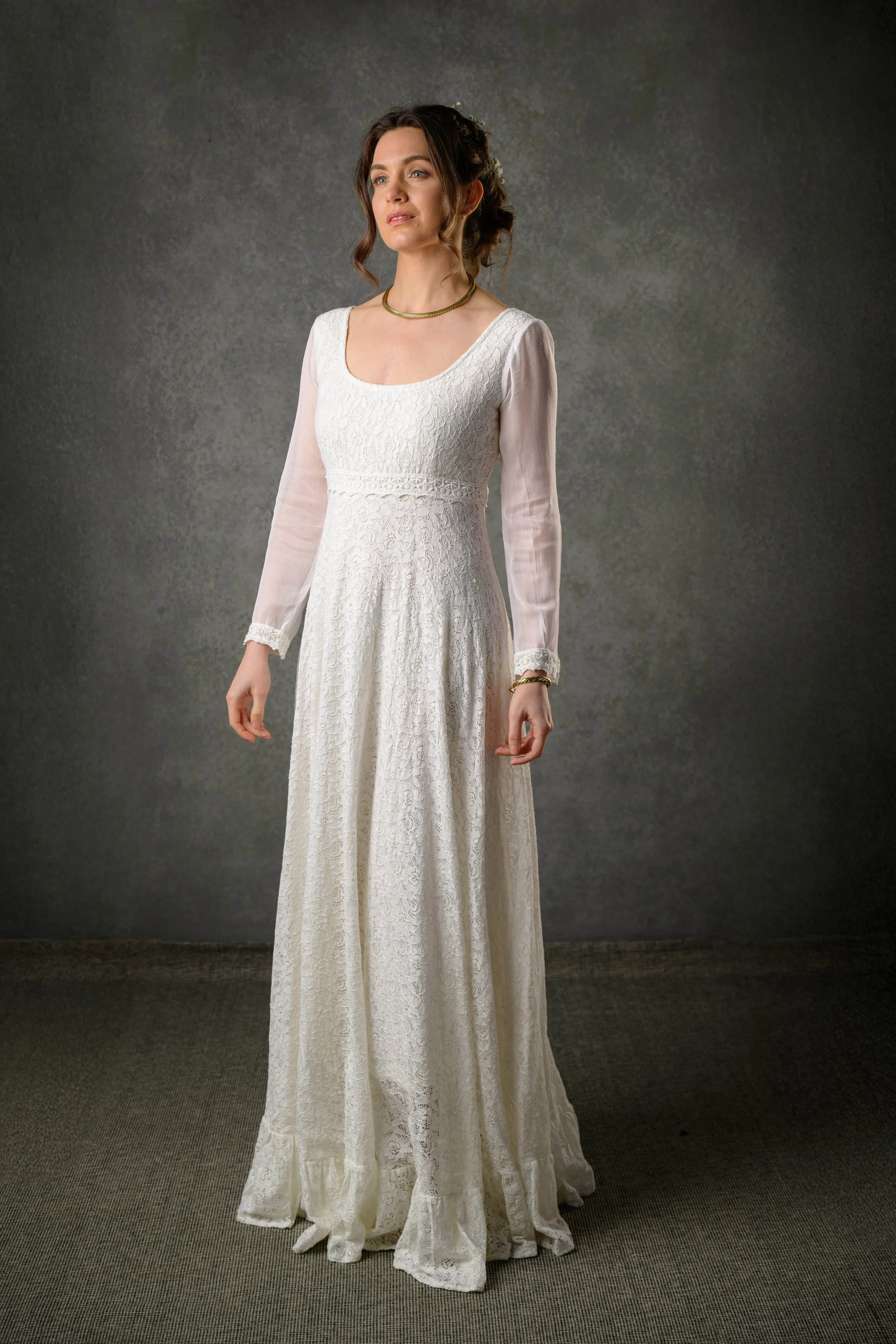 Regency style cotton lace wedding dress with bishop chiffon sleeves and a low scoop back. Features delicate waist lace trim and a ruffled hem.