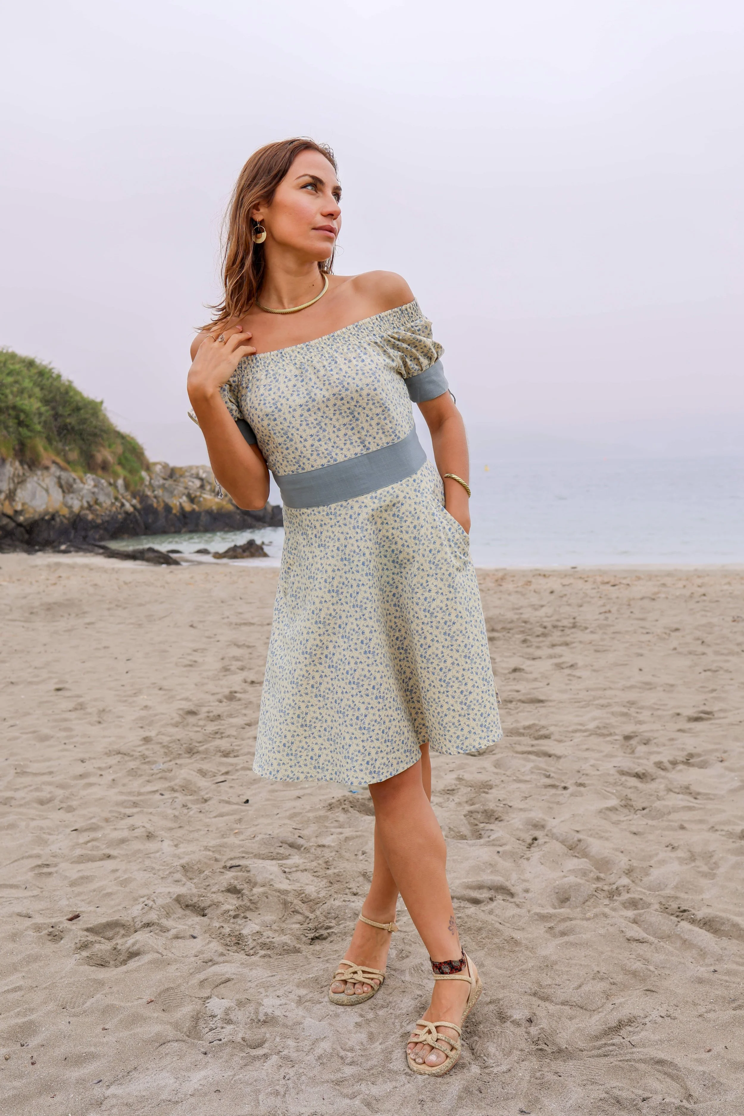 The Forget Me Not Linen Dress, a blue floral linen dress with contrast blue waistband, off-shoulder neckline, and A-line silhouette, the perfect garden party wedding guest dress.