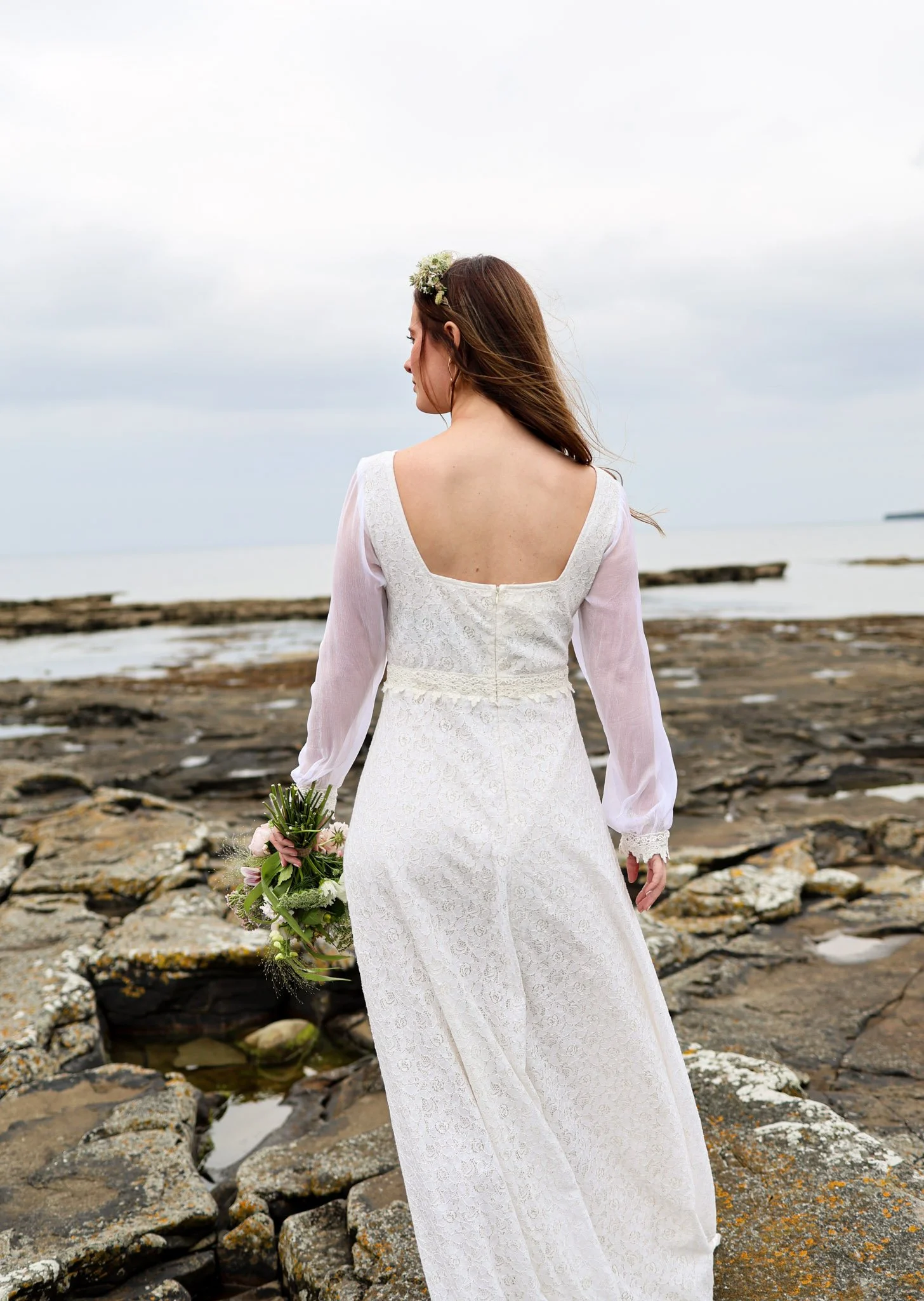 The Annagh Wedding Dress is an elegant cotton lace bridal gown with flowing bishop chiffon sleeves, a romantic low back, and ethical slow fashion values