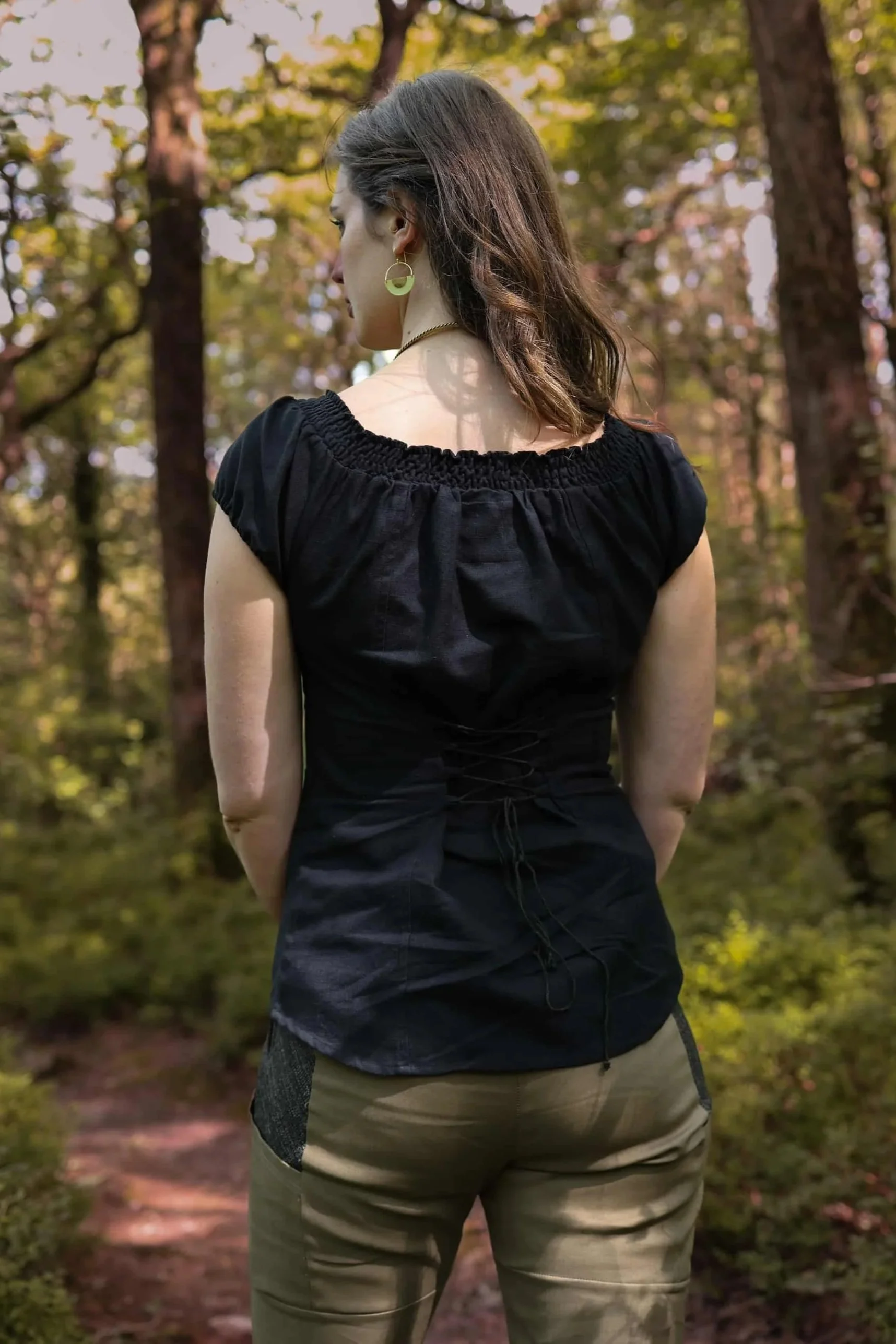 A romantic black corset top inspired by folklore style, featuring puffed sleeves, cotton lace detailing, and a flattering corset tie back.