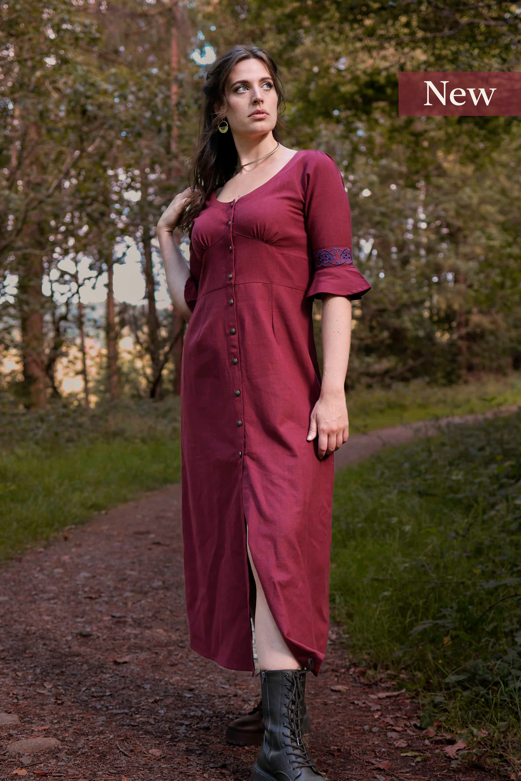 Model wearing a deep berry red Celtic dress with Celtic knot embroidery, button-down front, and flowing sleeves – Pooka Hawthorn Dress by Celtic Fusion Design