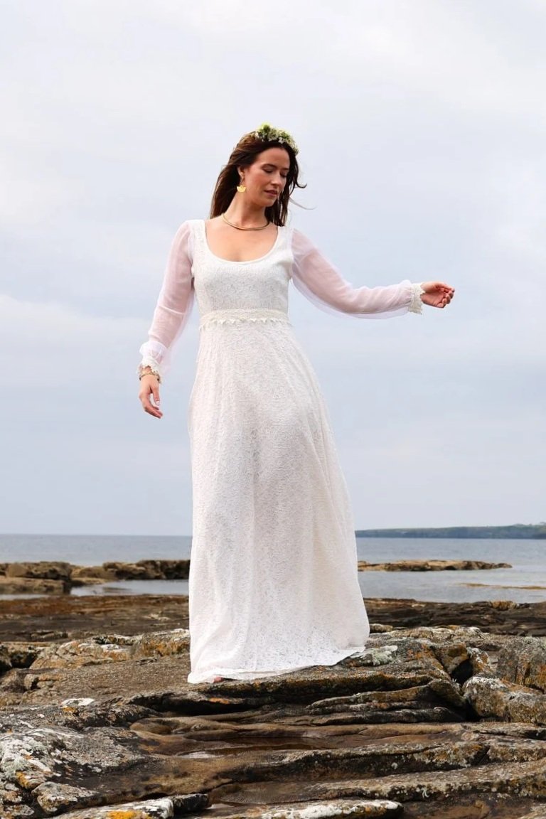 The Annagh Wedding Dress is an elegant cotton lace bridal gown with flowing bishop chiffon sleeves, a romantic low back, and ethical slow fashion values
