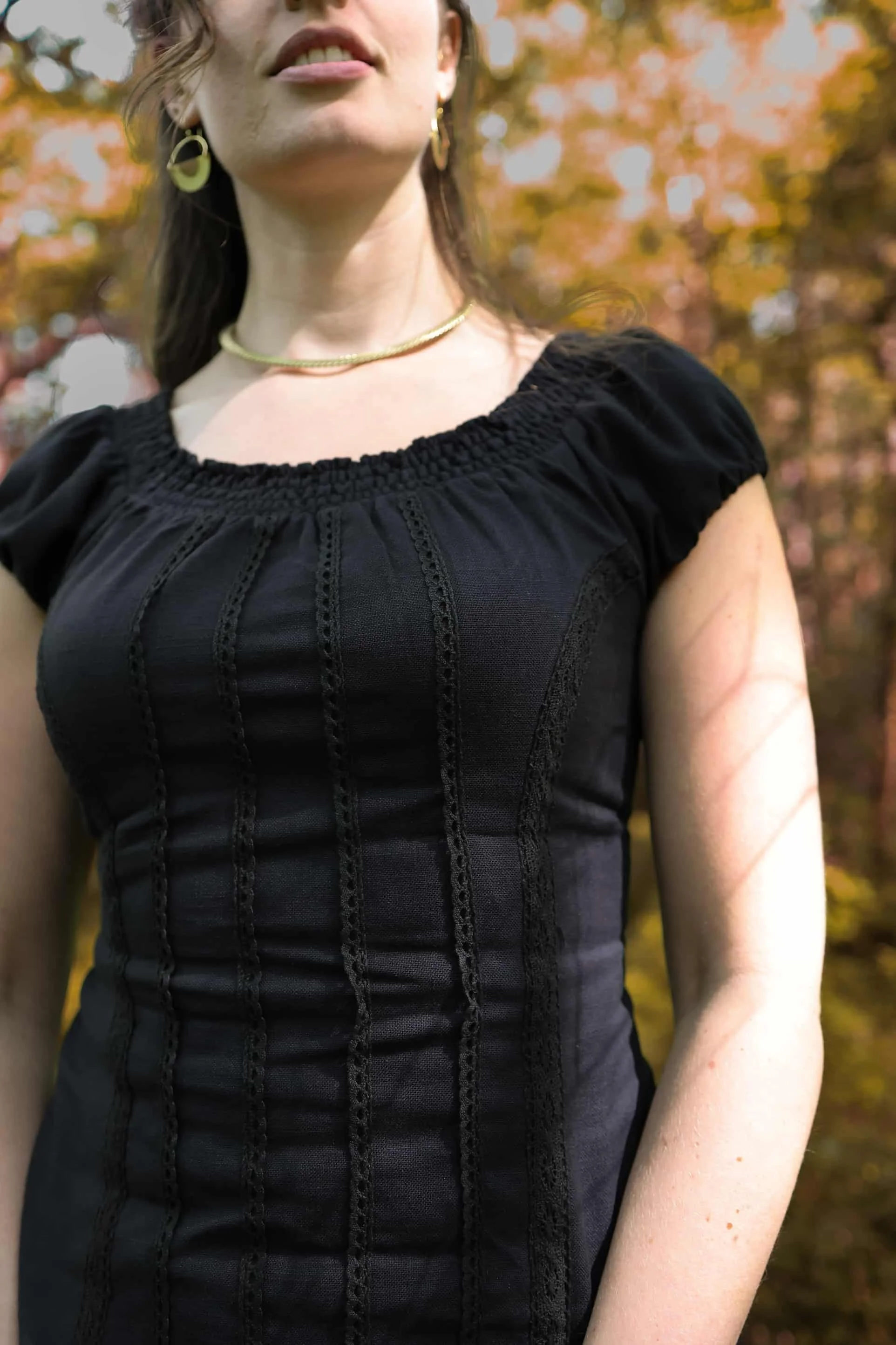 A romantic black corset top inspired by folklore style, featuring puffed sleeves, cotton lace detailing, and a flattering corset tie back.