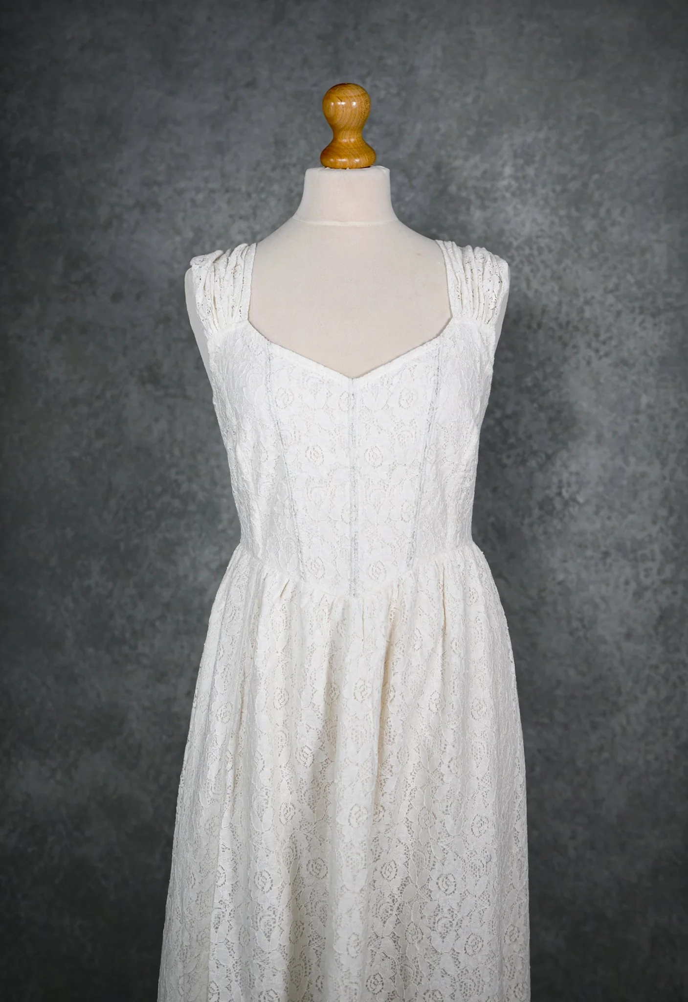 White Irish lace wedding dress with corset-style back, gathered lace straps, and flowing skirt with side slit—romantic Irish Celtic bridal design.