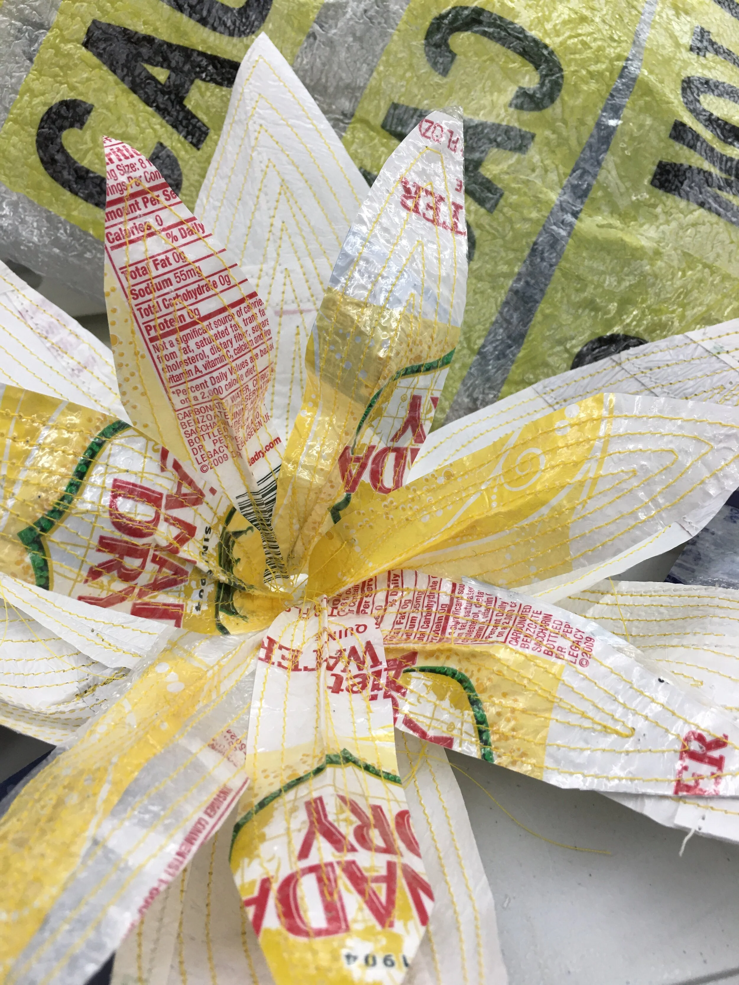 I began collecting this single-use plastic and fusing it together to create a more rigid material that I found could be sewn together to create a form of social discourse art that recognizes and brings attention to the negative side of consumerism.