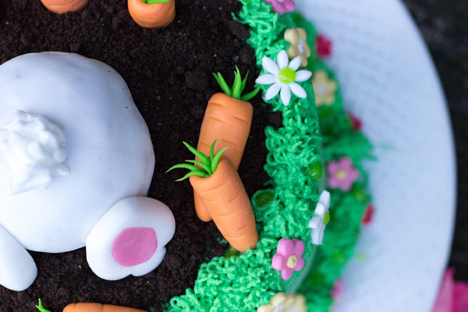 Ostertörtchen mit Hasen und süßen Karotten in einer Blumenwiese