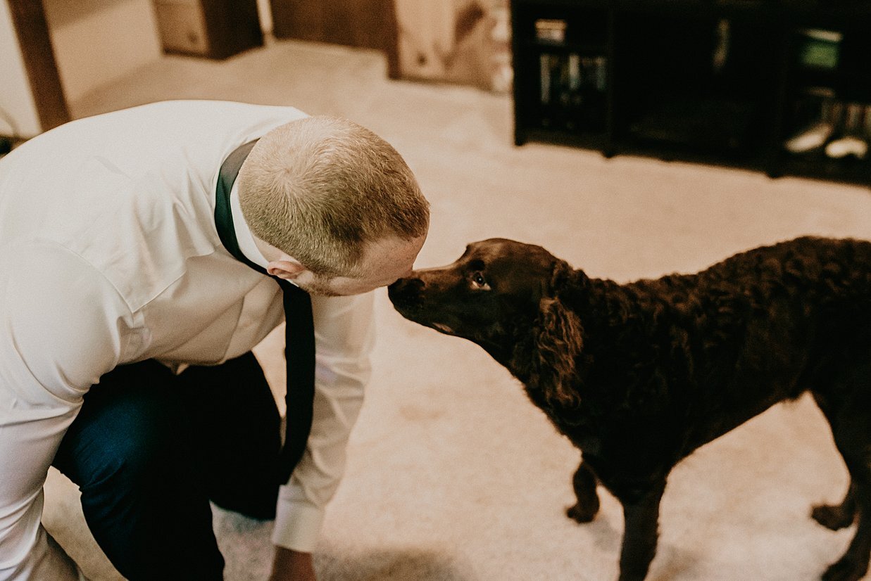 groom and labradoodle getting ready for intimate backyard wedding 