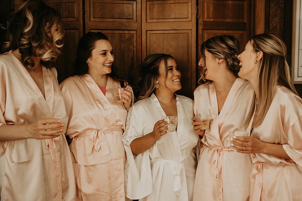  bridesmaids at backyard wedding in custom robes with champagne 