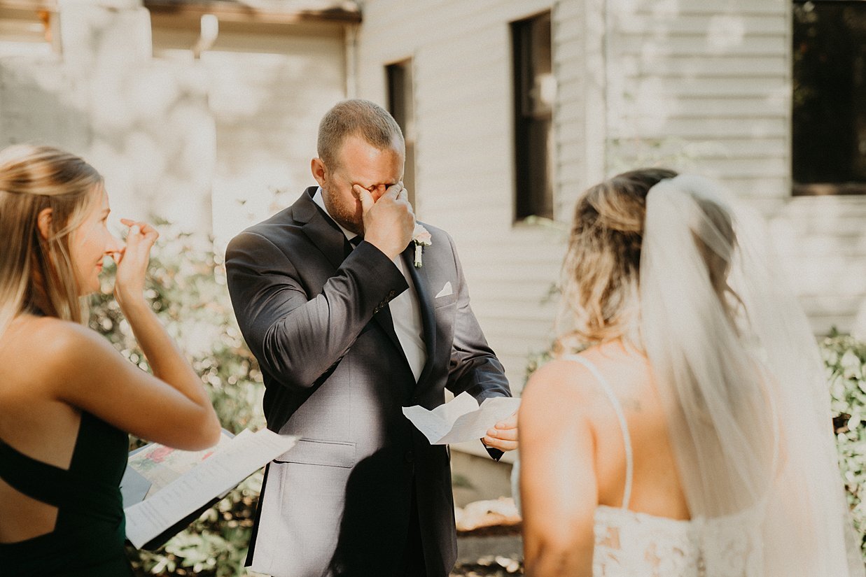  groom crying during bride’s vows at wedding in their own backyard 