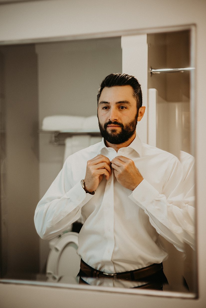  groom getting ready in suite at alderbrook resort and spa 