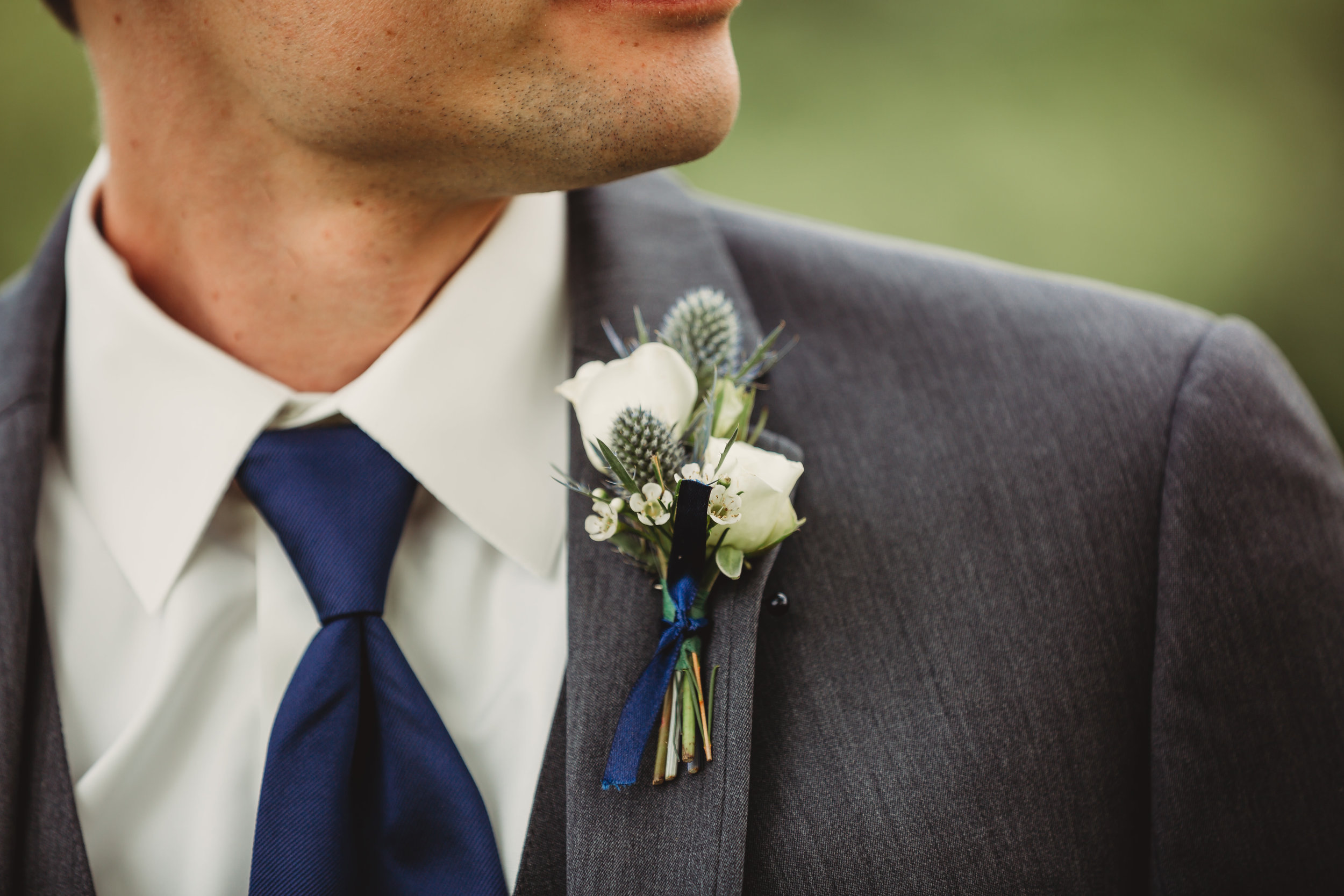 White boutonniere with blue thistle