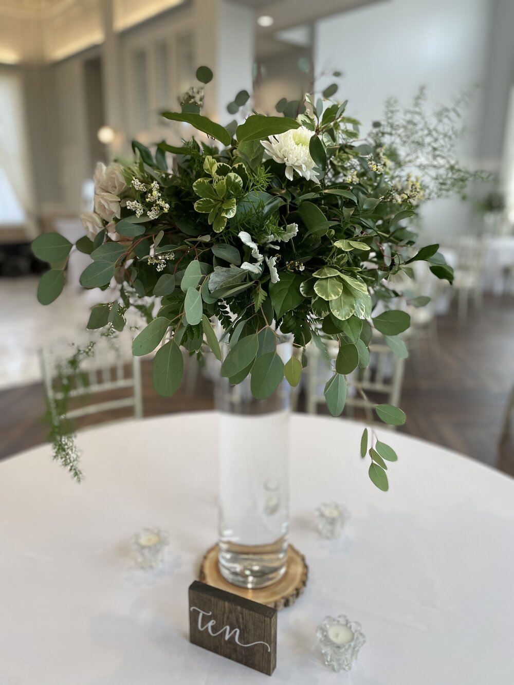 Table centerpiece with greenery and cylinder vase