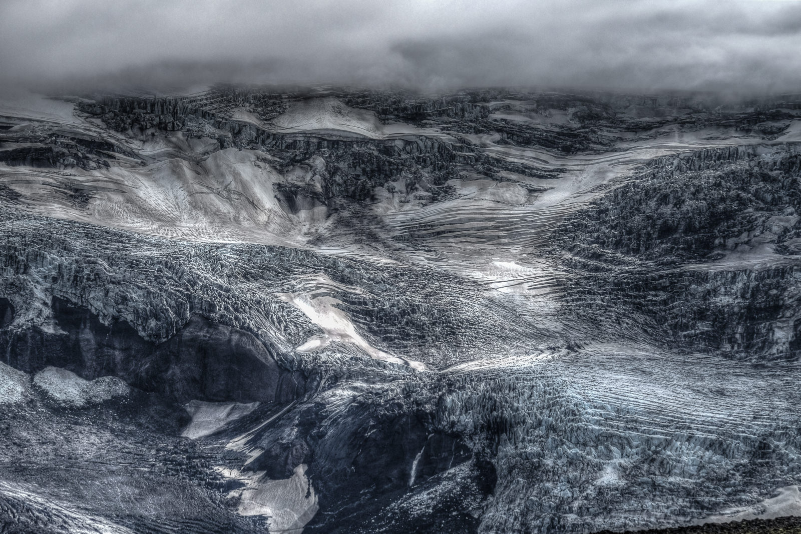 One of the Þórsmörk glaciers under the clouds, the glacier ice folded and scrambled like a frozen image of crashing waves.