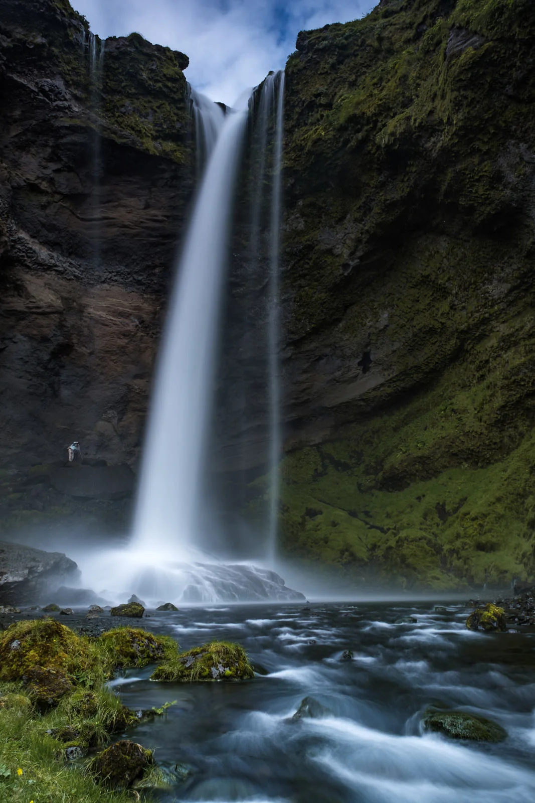 A photographer takes a shot from behind the main waterfall at Kvernufoss Falls, South Iceland (XF 16-55mm f2.8 at 24mm 1/2s f10 ISO200)