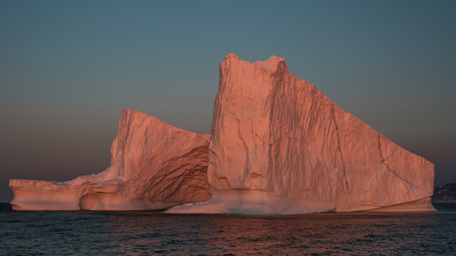 shadow of our boat at the bottom of the iceberg during sunset