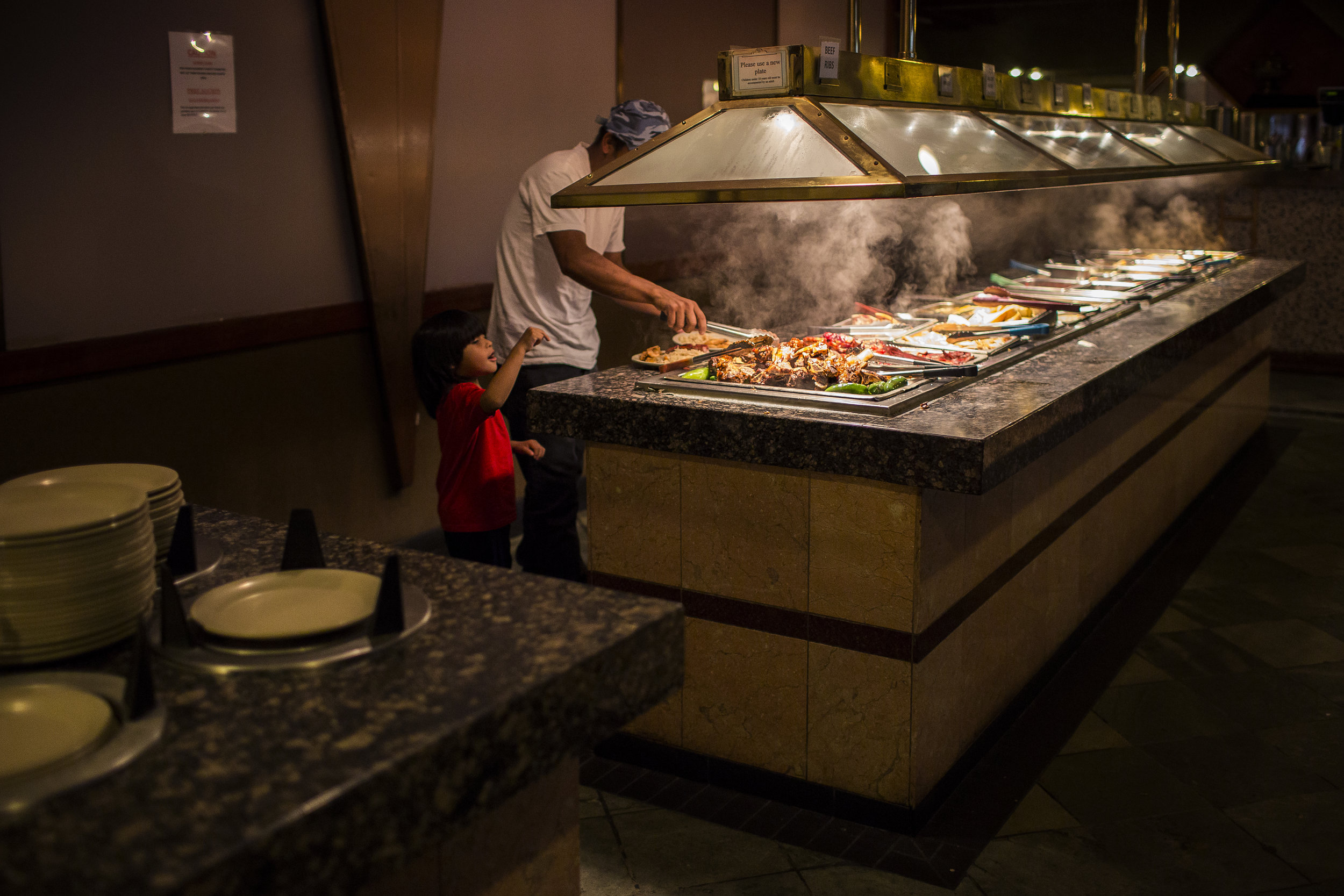  Dikeni serves himself and Fransuas food at a Chinese buffet, their first stop upon Dikeni and Fransuas' arrival in Houston on Jun. 10, 2017. Martin do Nascimento for The Texas Tribune. 