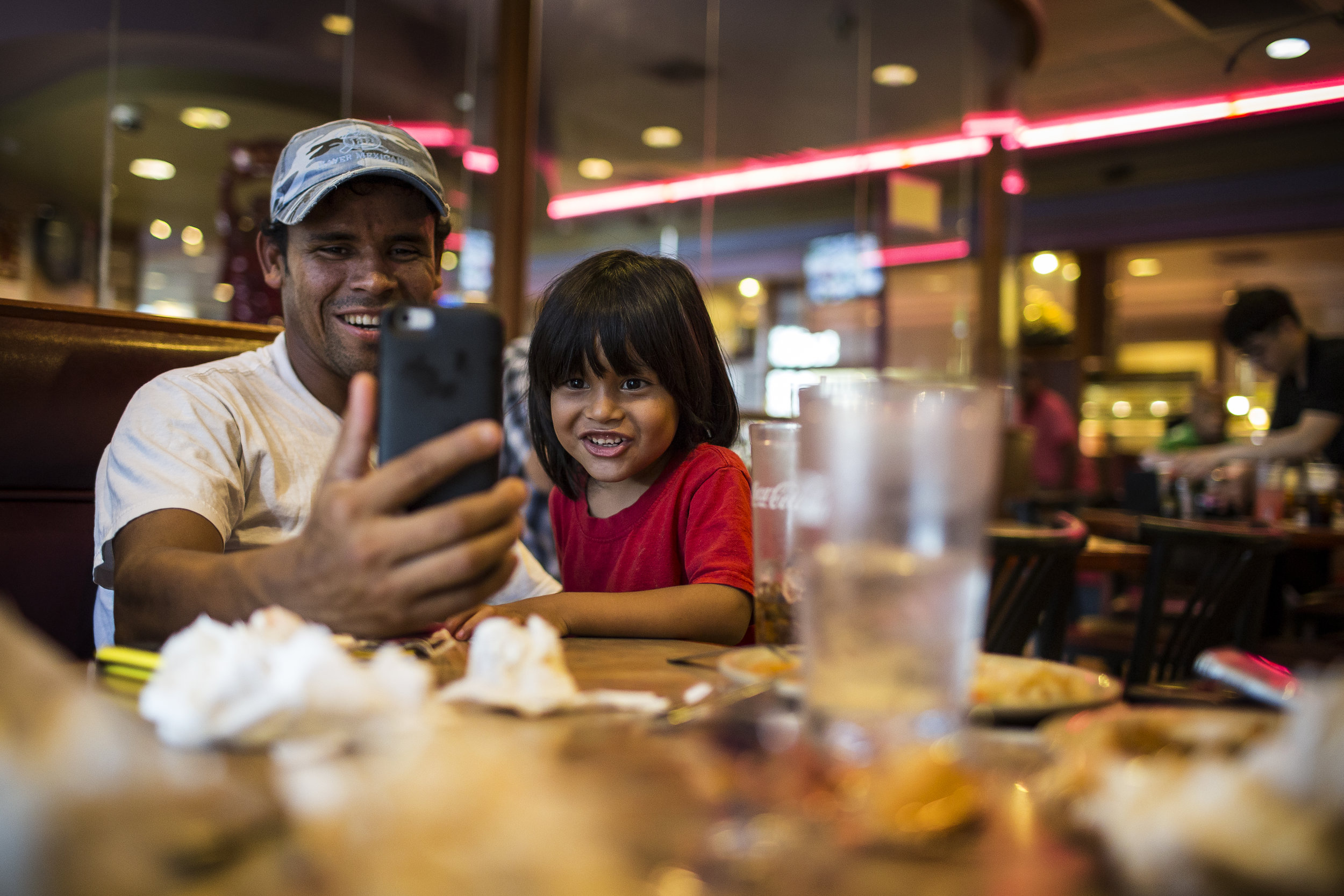  Dikeni and Fransuas (3) video-chat with Karina and Caleb (1), who are in Tijuana, from a Chinese buffet, their first stop upon their arrival in Houston on Jun. 10, 2017. Martin do Nascimento for The Texas Tribune. 