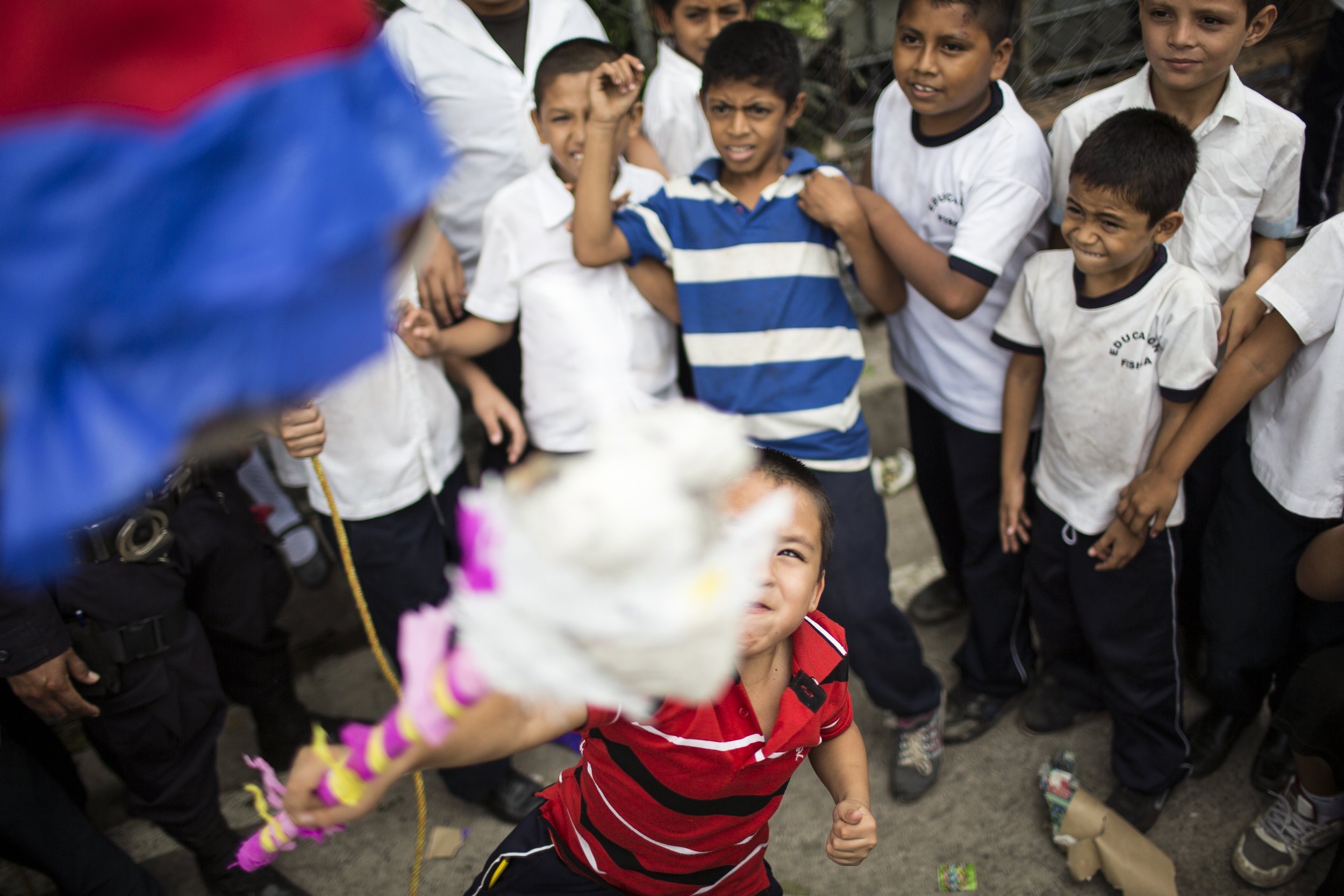  Students take turns whacking at the piñatas that local police officers have brought to celebrate their on-going drug prevention educational programming at the Centro Escolar "Caserio El Pital C/Entre Rios" elementary school in Lourdes, El Salvador. 