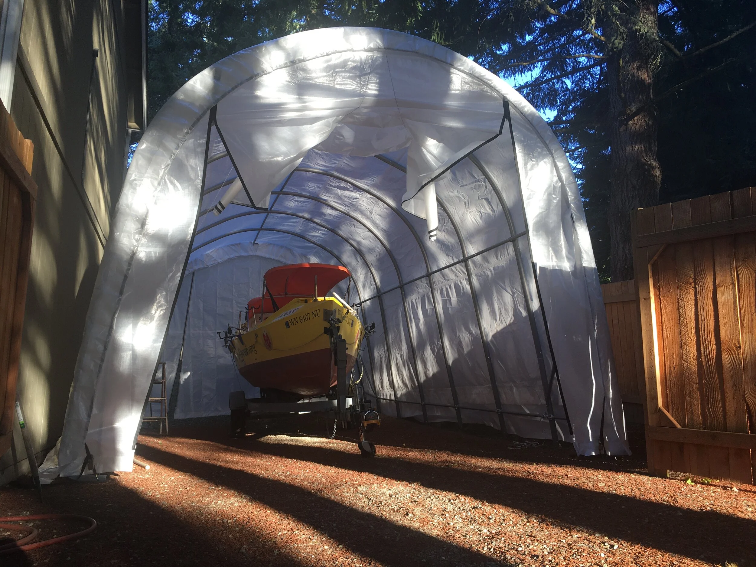 The canopy shelter for my plywood rowboat will double as a workshop.