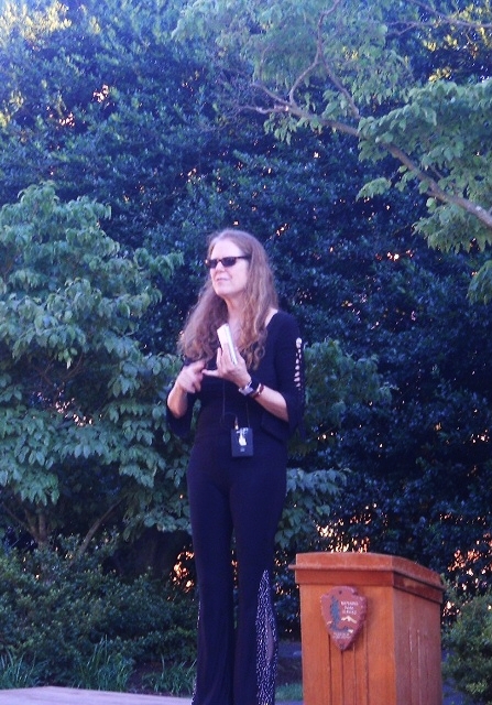 Barbara speaking outdoors by a podium
