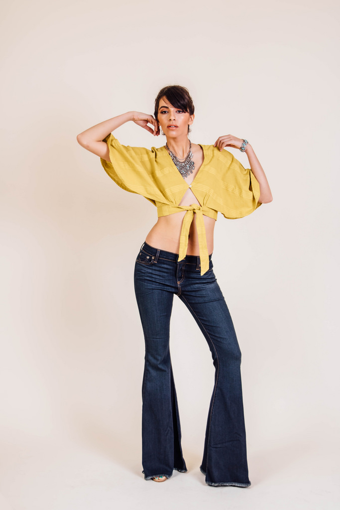 The Livin Is Easy Cape in Chartreuse by Free People. Ella Denim Super Flares by Free People. Shoes, model's own. Turquoise and Chain Bib Necklace by Express.