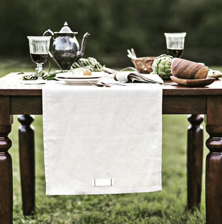 Photograph of a beautiful outdoor dining spread, featuring products from Heirloomed Collection.