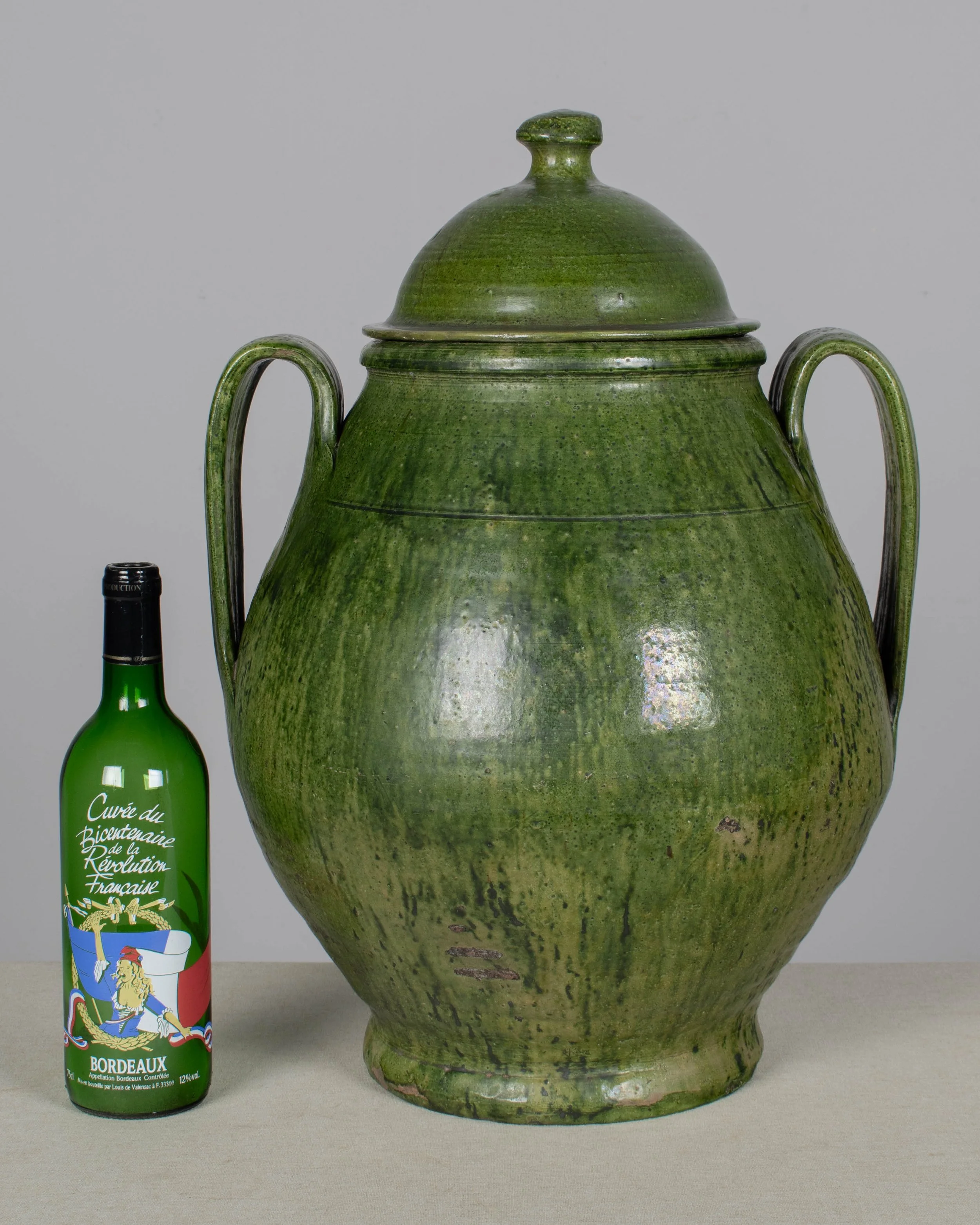A large green glazed earthenware lidded jar made in Portugal
