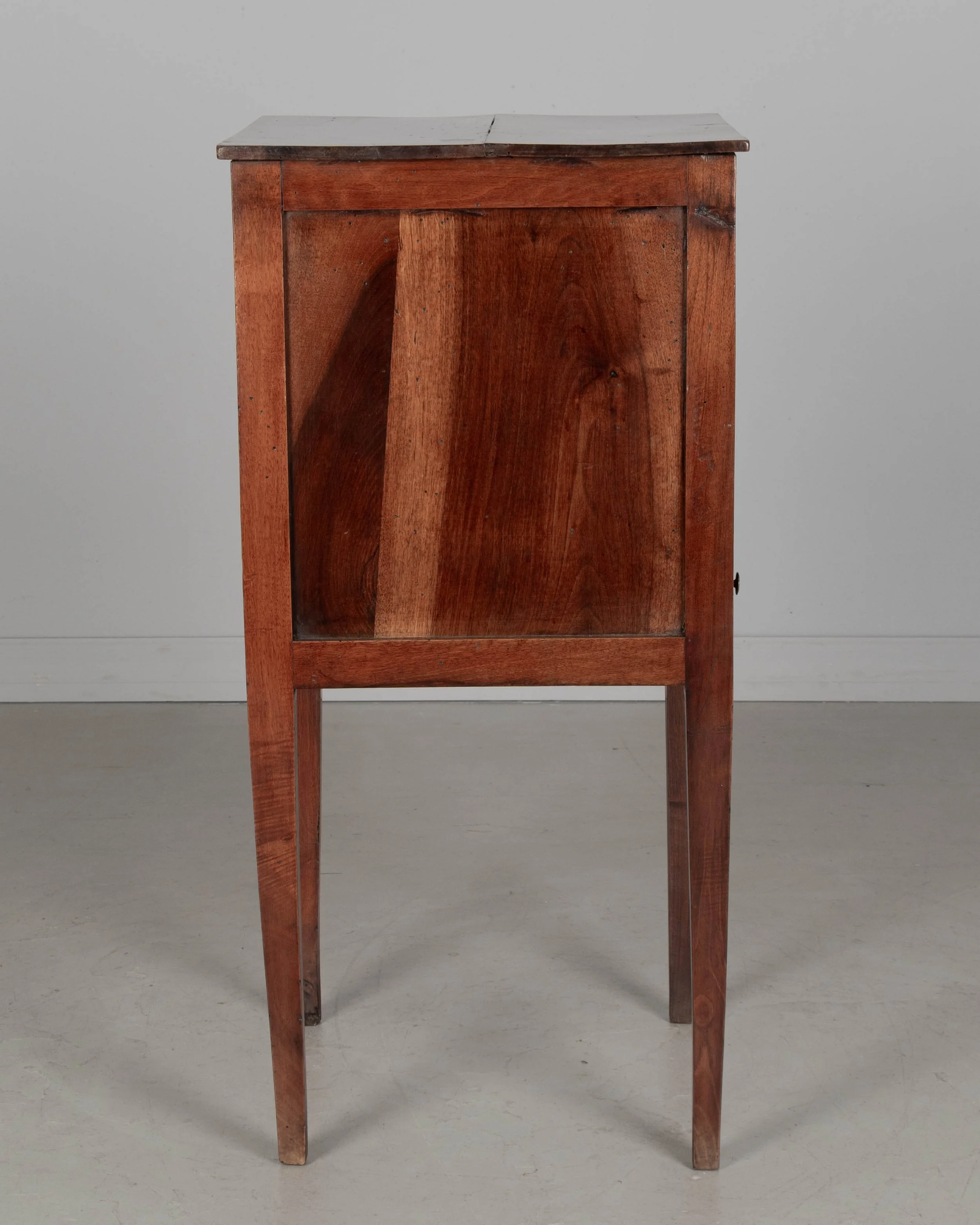 A 19th century French Country walnut side table, or nightstand, with a vertical tambour door above a slim dovetailed drawer