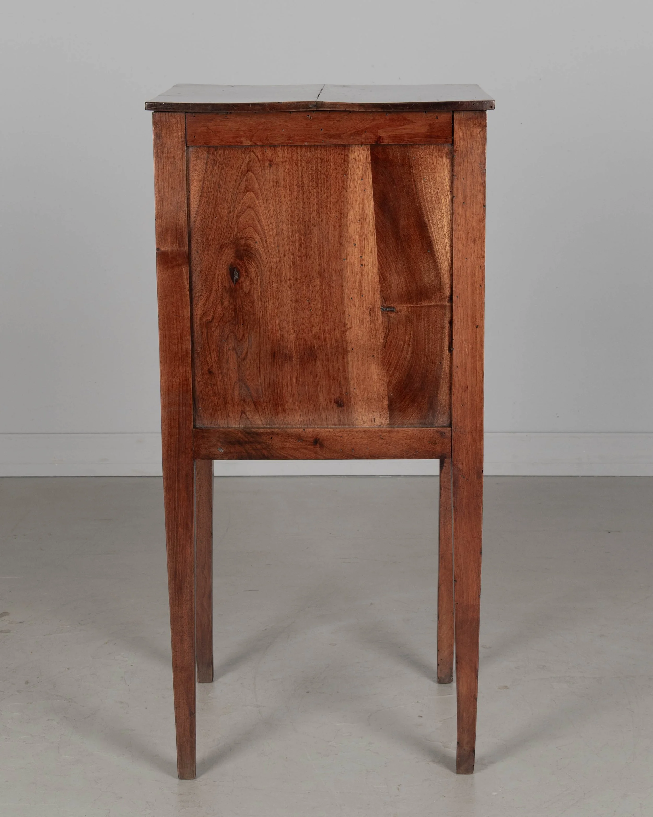 A 19th century French Country walnut side table, or nightstand, with a vertical tambour door above a slim dovetailed drawer