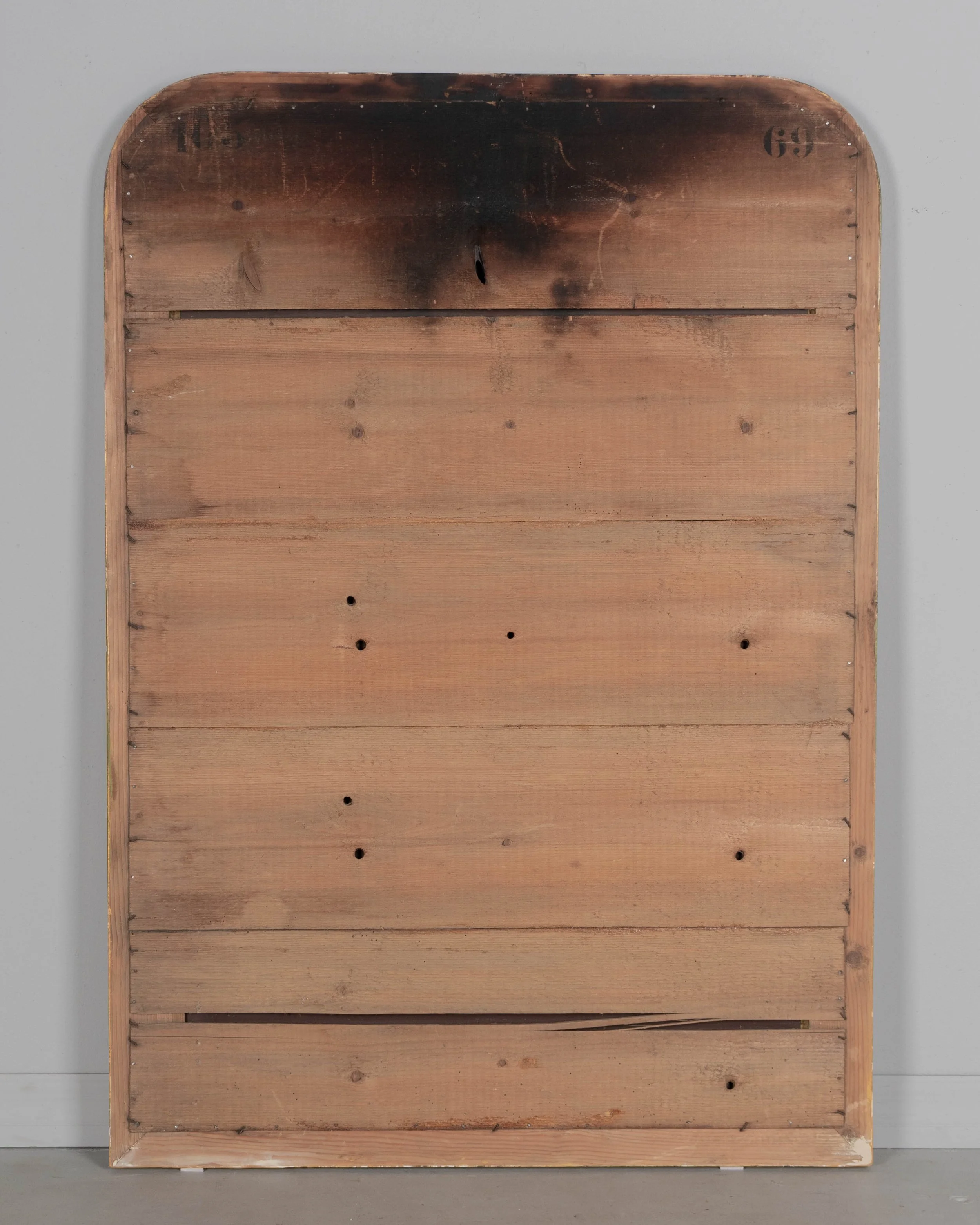 An early 20th century French Louis Philippe style gilded mirror with curved top corners, incised floral decoration and inner bead border.